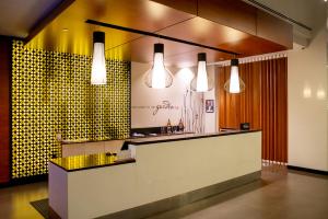 a restaurant with a counter and three lights at Hilton Garden Inn Nairobi Airport in Nairobi
