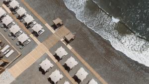 an overhead view of a beach with chairs and the ocean at Sagredo Boutique Hotel & Spa in Ágios Fokás