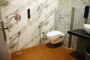 a bathroom with a toilet and a shower and a sink at Hotel Enclave Bikaner in Bikaner