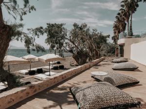 a resort with several tables and umbrellas and the ocean at Sagredo Boutique Hotel & Spa in Ágios Fokás
