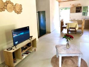 a living room with a television and a table at Petite maison 2ch a deux pas de la route principale in Andilana