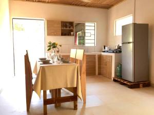 a kitchen with a table and a refrigerator at Petite maison 2ch a deux pas de la route principale in Andilana