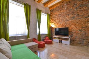 un salon avec un canapé et un mur de briques dans l'établissement Michael Weiss apartment, à Braşov