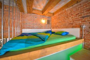 un lit dans une chambre avec un mur de briques dans l'établissement Michael Weiss apartment, à Braşov