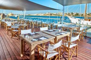 a restaurant on a boat with tables and chairs at NH Marina Portimao Resort in Portimão