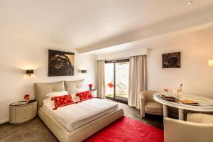 a bedroom with a bed and a table in a room at Mangio Fango Hotel et Spa in Saintes-Maries-de-la-Mer