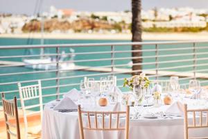 a table with chairs and wine glasses on a boat at NH Marina Portimao Resort in Portimão