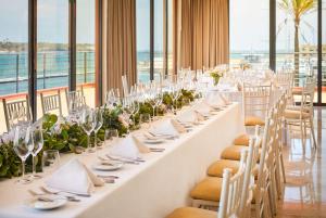 a long table set up for a wedding with white tables and chairs at NH Marina Portimao Resort in Portimão