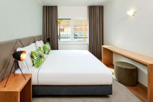 a bedroom with a large bed and a window at NH Marina Portimao Resort in Portimão