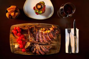 a table with a steak and a plate of food at NH Marina Portimao Resort in Portimão