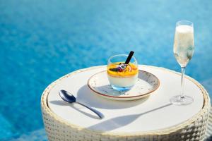 a drink on a plate next to a wine glass at NH Marina Portimao Resort in Portimão