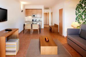 a living room with a couch and a table at NH Marina Portimao Resort in Portimão