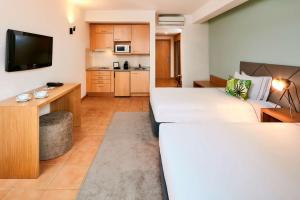 a living room with a couch and a kitchen at NH Marina Portimao Resort in Portimão