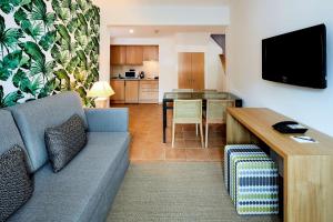 a living room with a couch and a table at NH Marina Portimao Resort in Portimão