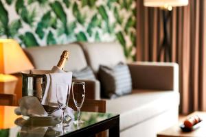a living room with a couch and a table with wine glasses at NH Marina Portimao Resort in Portimão