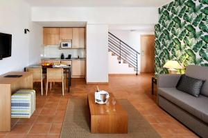 a living room with a couch and a table at NH Marina Portimao Resort in Portimão