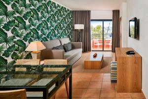 a living room with a couch and a table at NH Marina Portimao Resort in Portimão