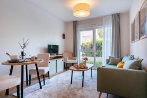 un salon avec un canapé et une table dans l'établissement Zenitude Hôtel-Résidences Ploërmel, à Ploërmel