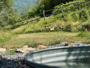a bath tub in front of a field with a fence at Cascina Chirè in Berioli