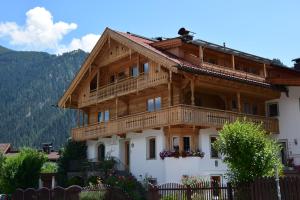Una casa de madera con un balcón en la parte superior. en Landhaus Noal, en Mayrhofen