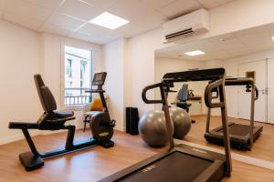 a gym with two treadmills and exercise bikes at Zenitude Hôtel-Résidences Ploërmel in Ploërmel