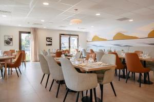 une salle à manger avec des tables et des chaises dans l'établissement Zenitude Hôtel-Résidences Ploërmel, à Ploërmel