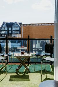 a patio with a table and chairs on a balcony at Appartement Spoorklokken in Bergen aan Zee