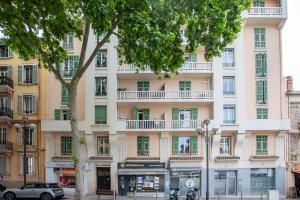 カンヌにあるStudio Blvd Carnot 10 min Palais Festivals - Balcony & ACの前に木がある大きな白い建物