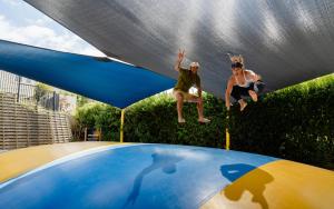 zwei Personen springen auf einem Trampolin in der Unterkunft Tasman Holiday Parks - Waihi Beach in Waihi Beach + 195 Fotos