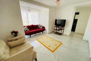 a living room with a red couch and a tv at E-My Marina Cesme in Cesme