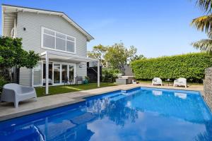 una piscina davanti a una casa di Amaroo - poolside studio near Pukekura Park a New Plymouth