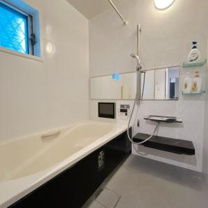 a white bathroom with a tub and a sink at アンドステイ野方2丁目 in Tokyo