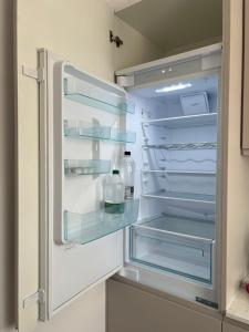 an empty refrigerator with its door open in a kitchen at City Nest Apartament in Rădăuţi