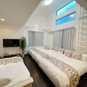 two beds in a room with a window at アンドステイ野方2丁目 in Tokyo