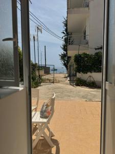 a bird sitting on a chair in front of a door at Qirjako's Rooms in Himare