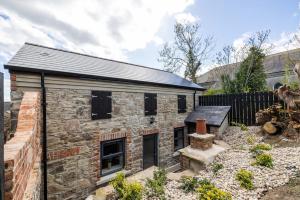 an old stone house with a black roof at Boutique Stays at 56B in Newtownards