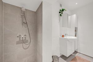 a white bathroom with a shower and a sink at Lovely Holiday Home, Completely Renovated In 2025, In Quiet And Beautiful Surroundings in Sønder Felding +32 photos