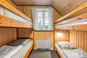 two bunk beds in a room with a window at Large Holiday Home With Pool, Spa And Sauna, 1500 Meters From The North Sea in Ulfborg +32 photos