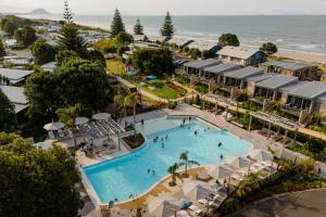 Una vista aérea de un resort con piscina y playa. en Tasman Holiday Parks - Papamoa Beach, en Papamoa