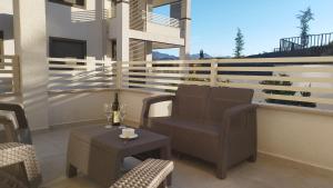 a patio with chairs and a table with a bottle of wine at Wind Rose Montenegro in Igalo