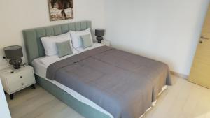 a bedroom with a large bed with a blue comforter at Wind Rose Montenegro in Igalo