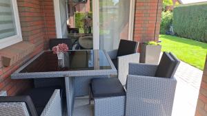 eine Terrasse mit einem Glastisch und Stühlen in der Unterkunft Irina in Eutin