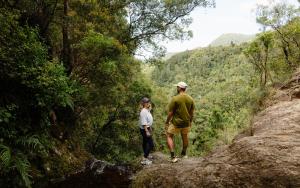 a man and a woman standing on a rock in a forest at Tasman Holiday Parks - Beachaven in Waihi Beach