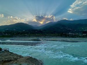 a view of a river with mountains in the background at Askari Inn Hotels in Madyan