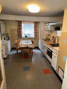 a kitchen with a table and a kitchen with white appliances at Spacious Local Lounge Apartment in Kelkheim