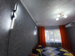 a bedroom with a bed and a ceiling with a window at Комфортная квартира Сабитовой 23а, район ЖД вокзал in Balqash