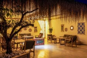 a living room with tables and chairs and a tree at Costa Maya Bodrum in Bodrum City