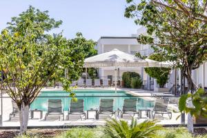 a swimming pool with chairs and a table and umbrella at Costa Maya Bodrum in Bodrum City