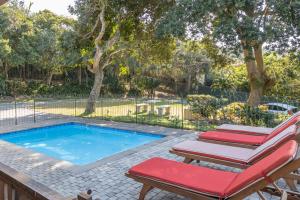 a swimming pool with two lounge chairs next to it at KERYNMERE, Zinkwazi Beach in Zinkwazi Beach