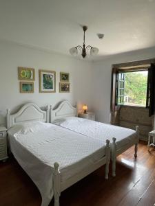 a white bed in a bedroom with a window at Quinta Do Sobreiro in Vila Verde +36 photos